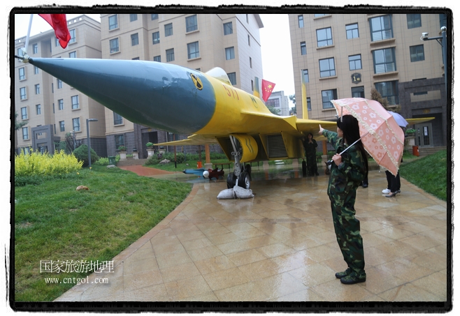 小區(qū)突然出現(xiàn)“飛機(jī)坦克”，其中殲15艦載戰(zhàn)斗機(jī)一架、99式主戰(zhàn)坦克一輛、武直-10武裝直升機(jī)一架，吸引了眾多市民雨中圍觀、合影。